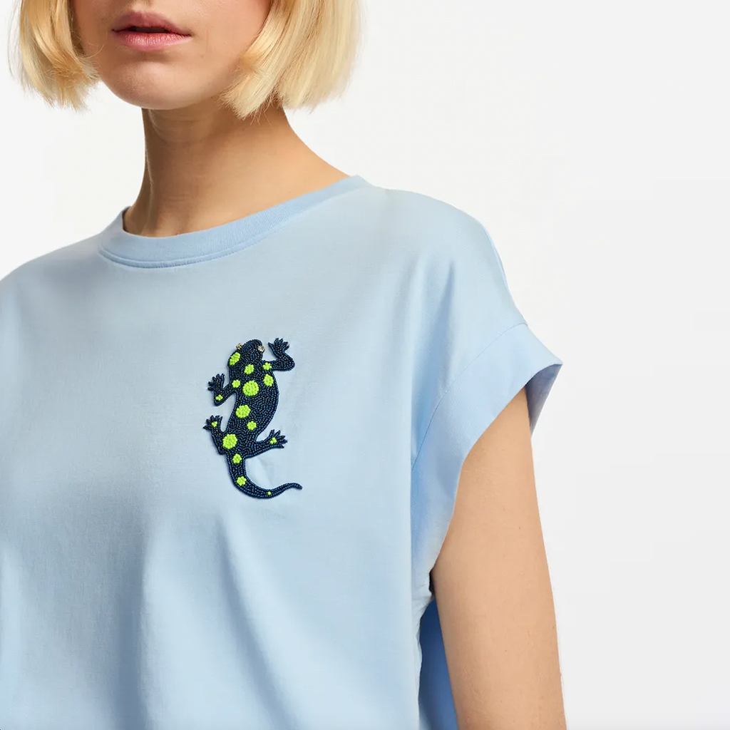 Weiches T-Shirt von Essentiel Antwerp aus Bio-Baumwolle, hellblau. Lockere, weite Passform mit eckigen Flügelärmeln. Etwa über Brusthöhe eine mit Perlen bestickte Eidechse.