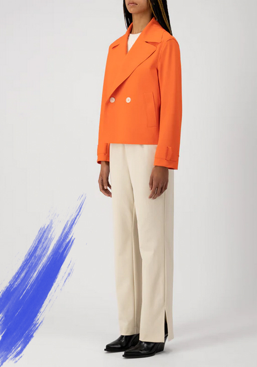 Kurze, orangefarbene Jacke von Harris Wharf, 2-Knopf-Verschluss mit breitem Revers und Seitennahttaschen. Weite, geradlinige Hose in cremefarben mit seitlichem Schlitz am unteren Ende